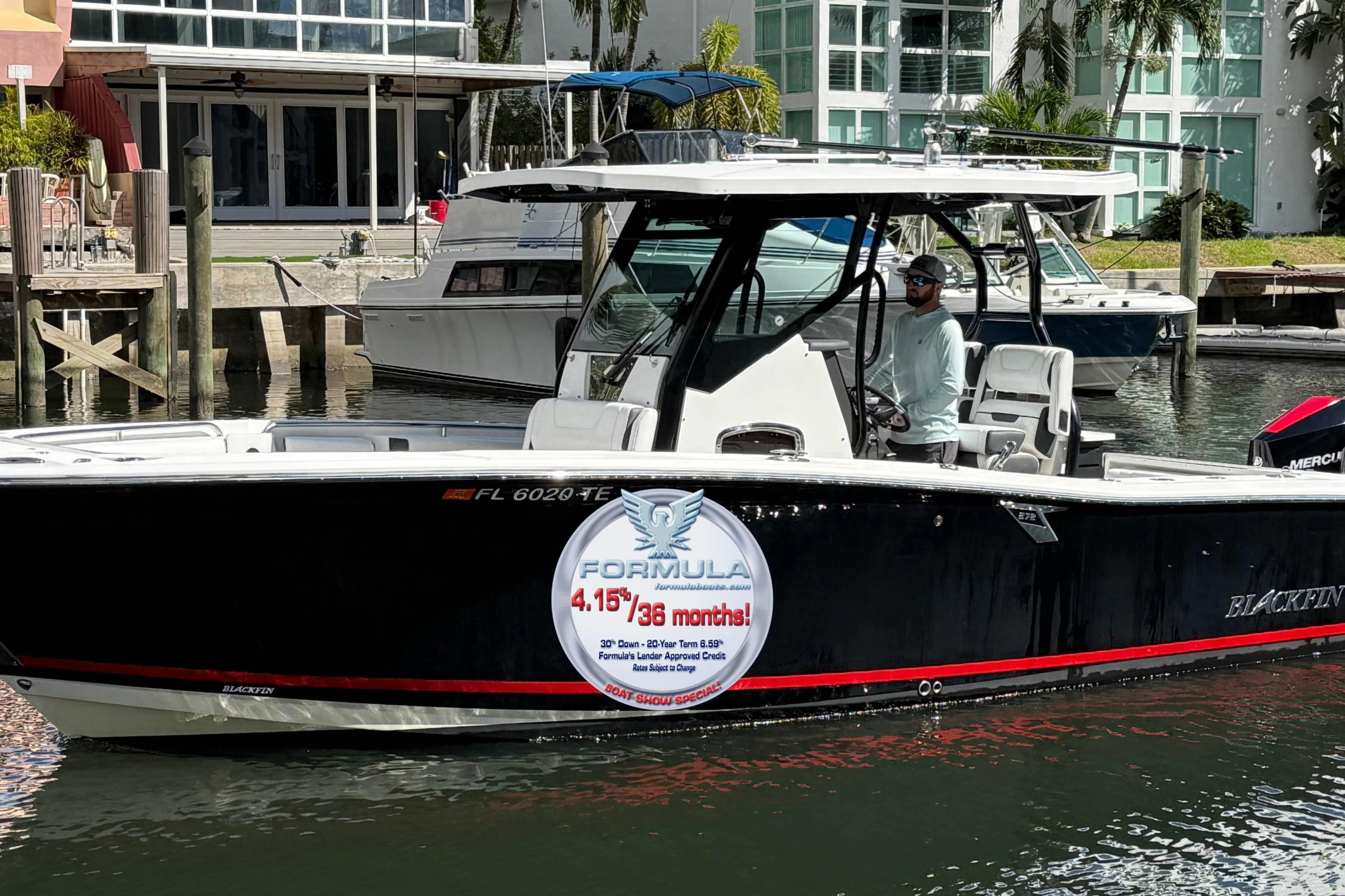 2022 Blackfin 272 CC boat docked, featuring promotional signage on the side.