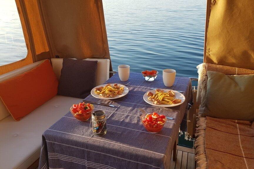 Cozy dining setup on Linssen Yachts' 2014 New Classic Sturdy 36 AC, overlooking serene waters.
