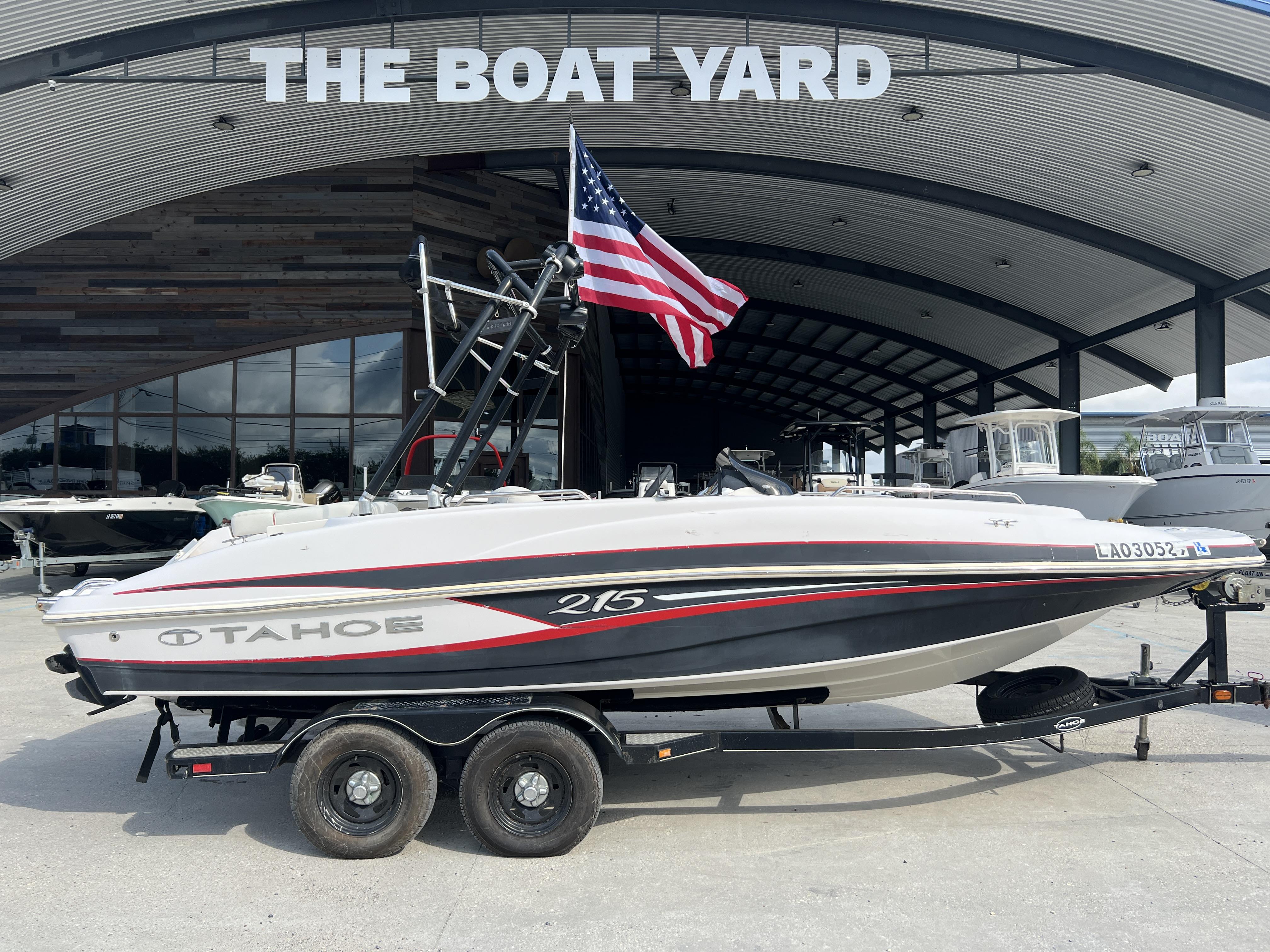 2016 Tahoe 215 boat on trailer at The Boat Yard, American flag displayed.