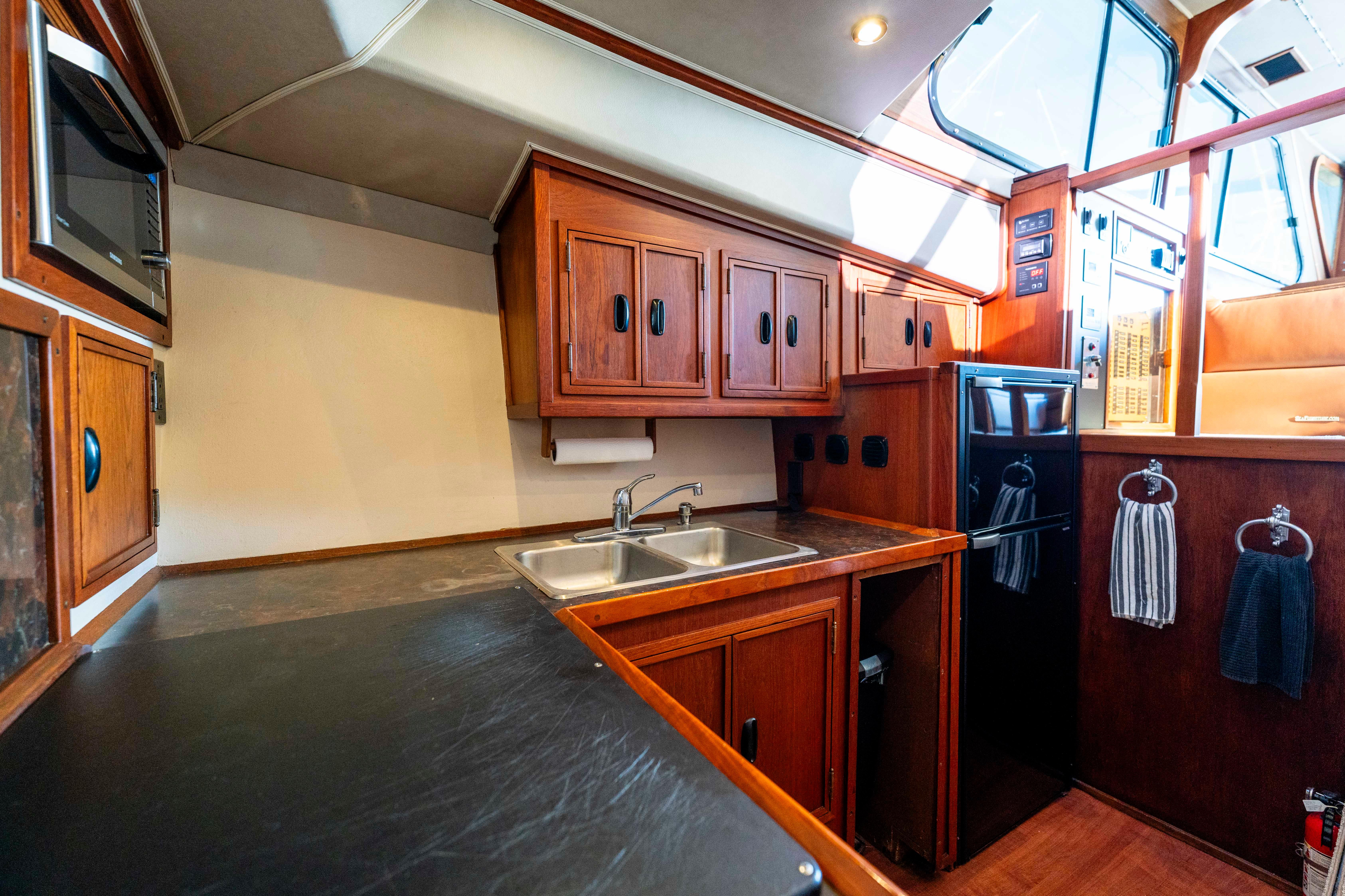 Pacifica-50 Convertible 1983-Bull Pen CA-US-1983 Pacifica 50 Convertible yacht kitchen with wooden cabinets and modern appliances.-9793604 | Thumbnail