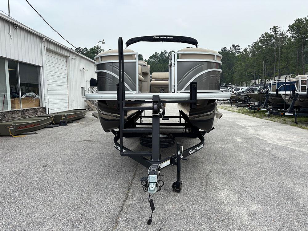 2025 Sun Tracker Party Barge 20 DLX pontoon boat on trailer in outdoor lot.
