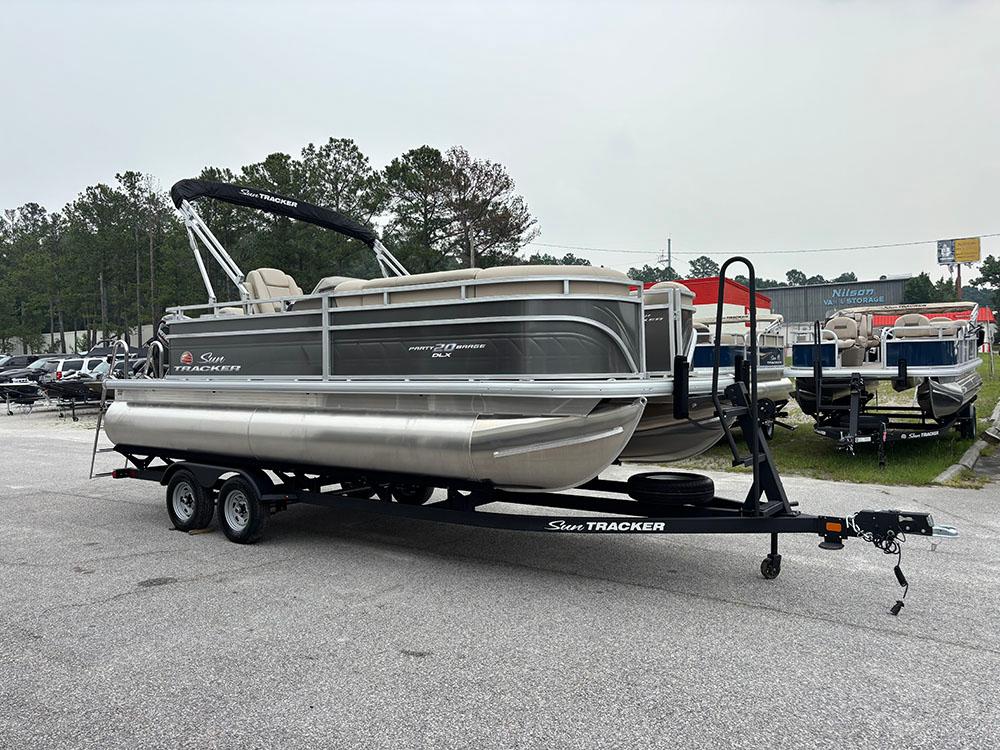 2025 Sun Tracker Party Barge 20 DLX pontoon boat on trailer in outdoor setting.