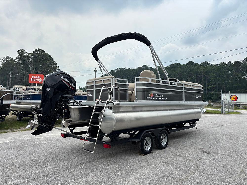 2025 Sun Tracker Party Barge 20 DLX pontoon boat on trailer, outdoor setting.