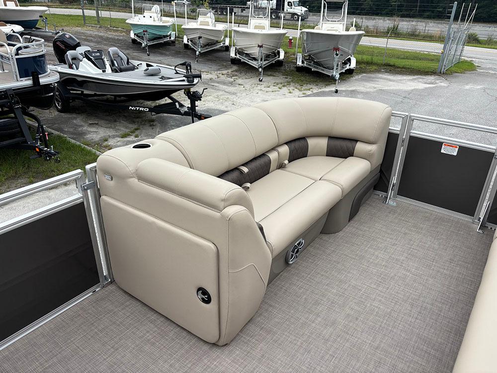 2025 Sun Tracker Party Barge 20 DLX with beige seating, docked near other boats.