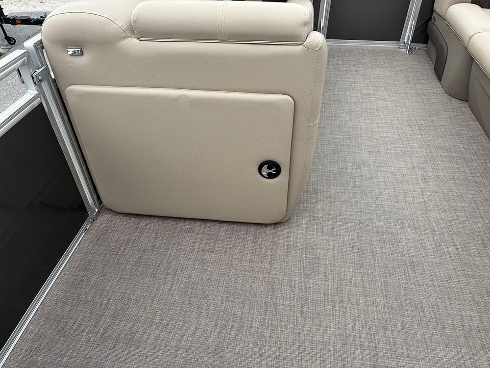 2025 Sun Tracker Party Barge 20 DLX interior with beige seating and textured flooring.