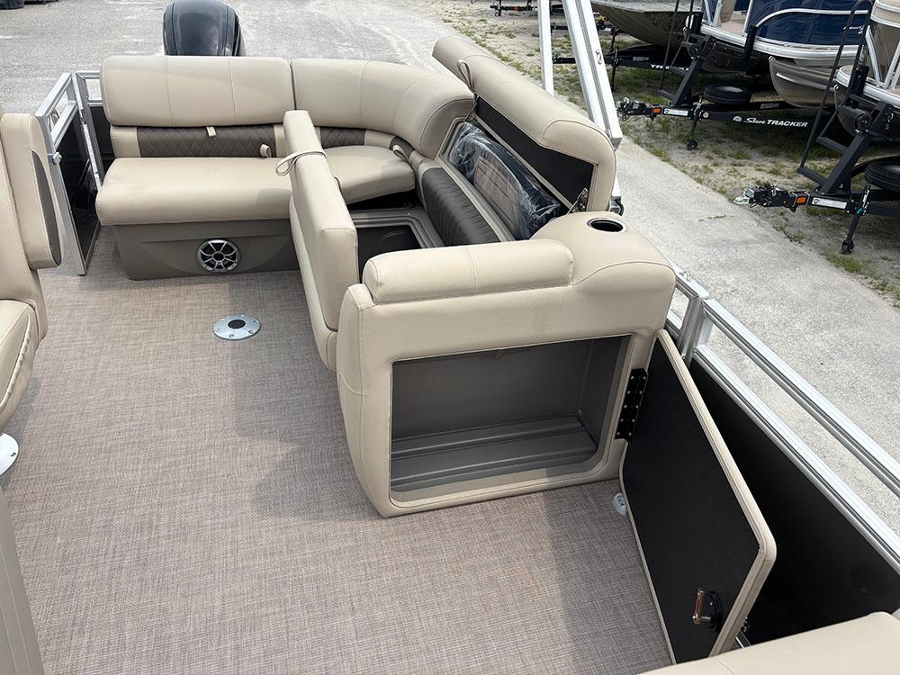 2025 Sun Tracker Party Barge 20 DLX interior with beige seating and storage compartments.