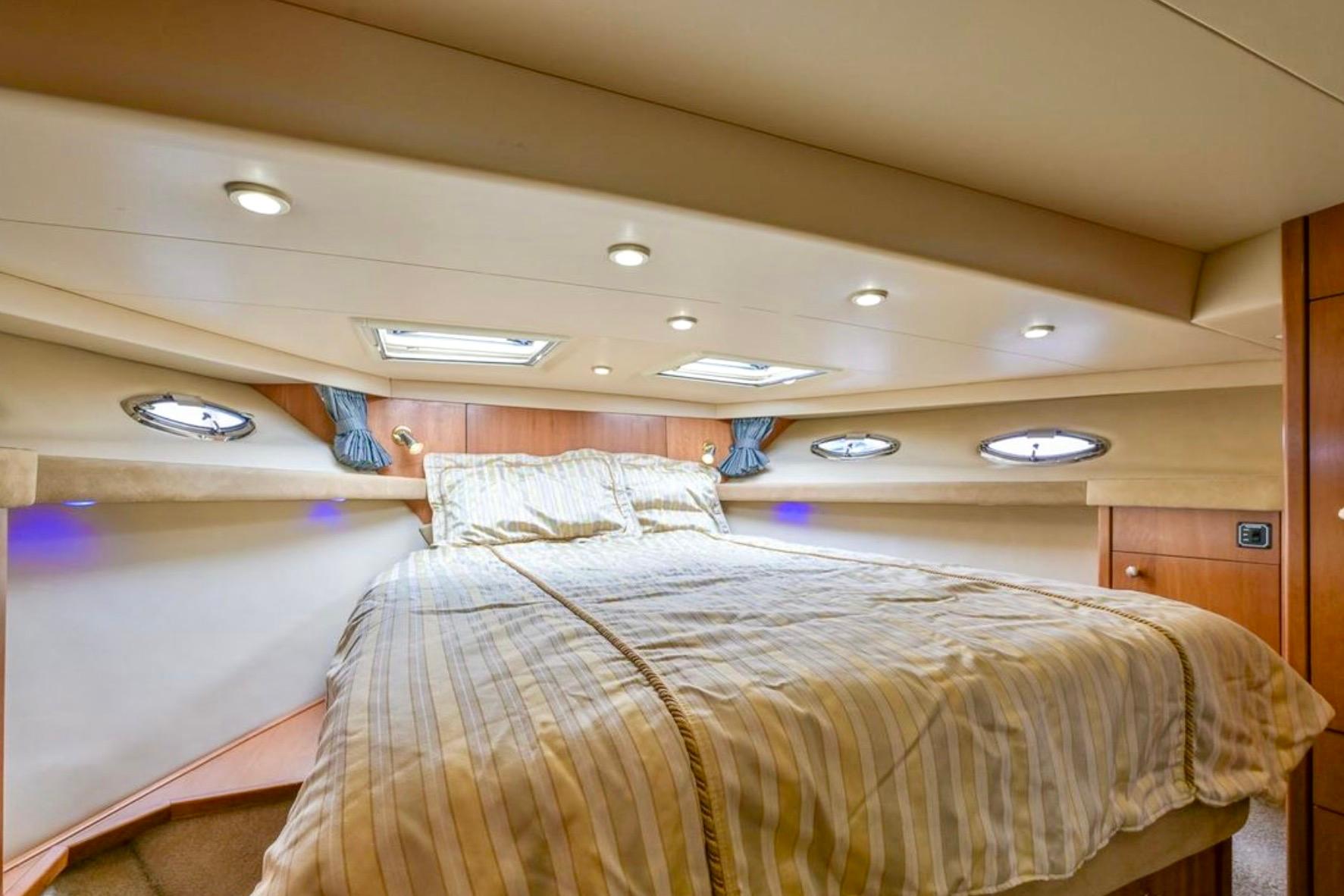 Luxurious bedroom interior of 2004 Meridian 490 Pilothouse yacht with elegant lighting.