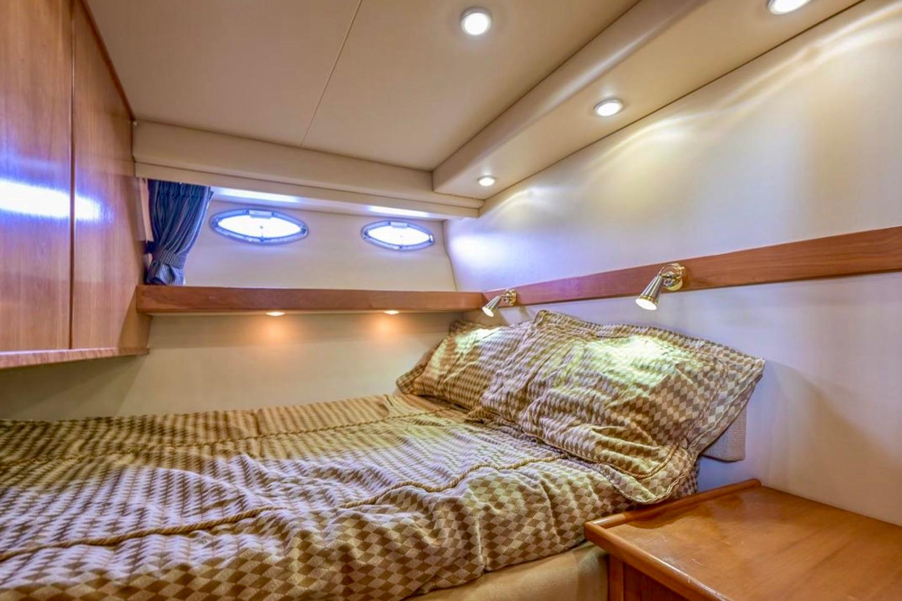 Luxurious cabin interior of 2004 Meridian 490 Pilothouse yacht with cozy bedding.