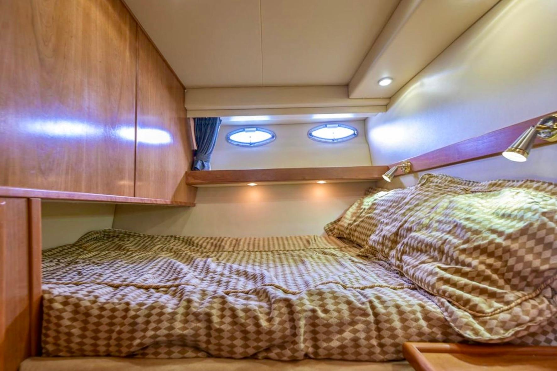 Cozy cabin interior of 2004 Meridian 490 Pilothouse with wood paneling and porthole windows.