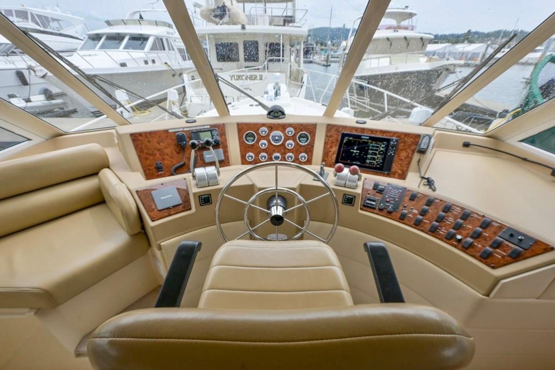 Pilothouse interior of 2004 Meridian 490, featuring steering wheel and control panel.