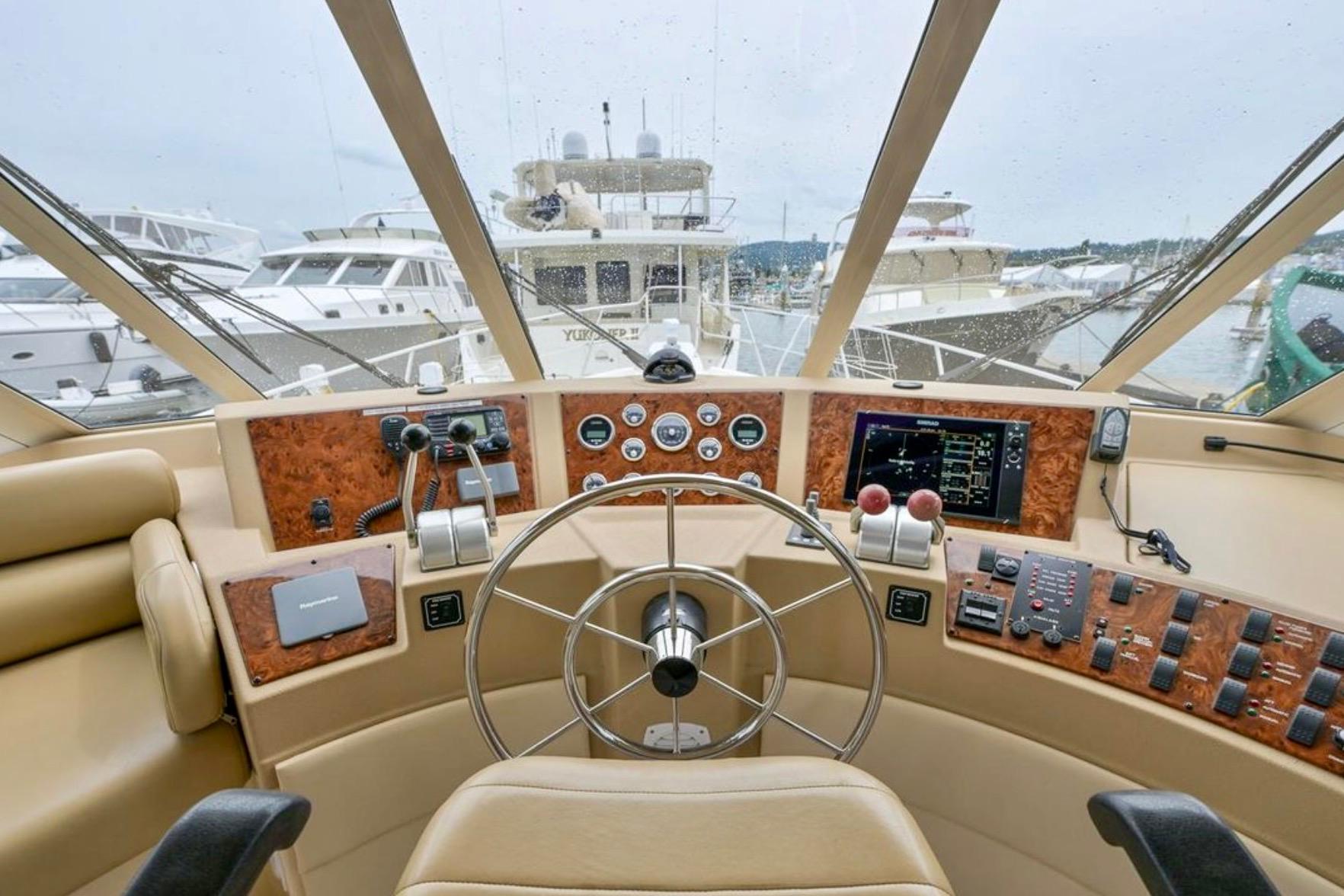 Pilothouse interior of 2004 Meridian 490, featuring steering wheel and navigation controls.