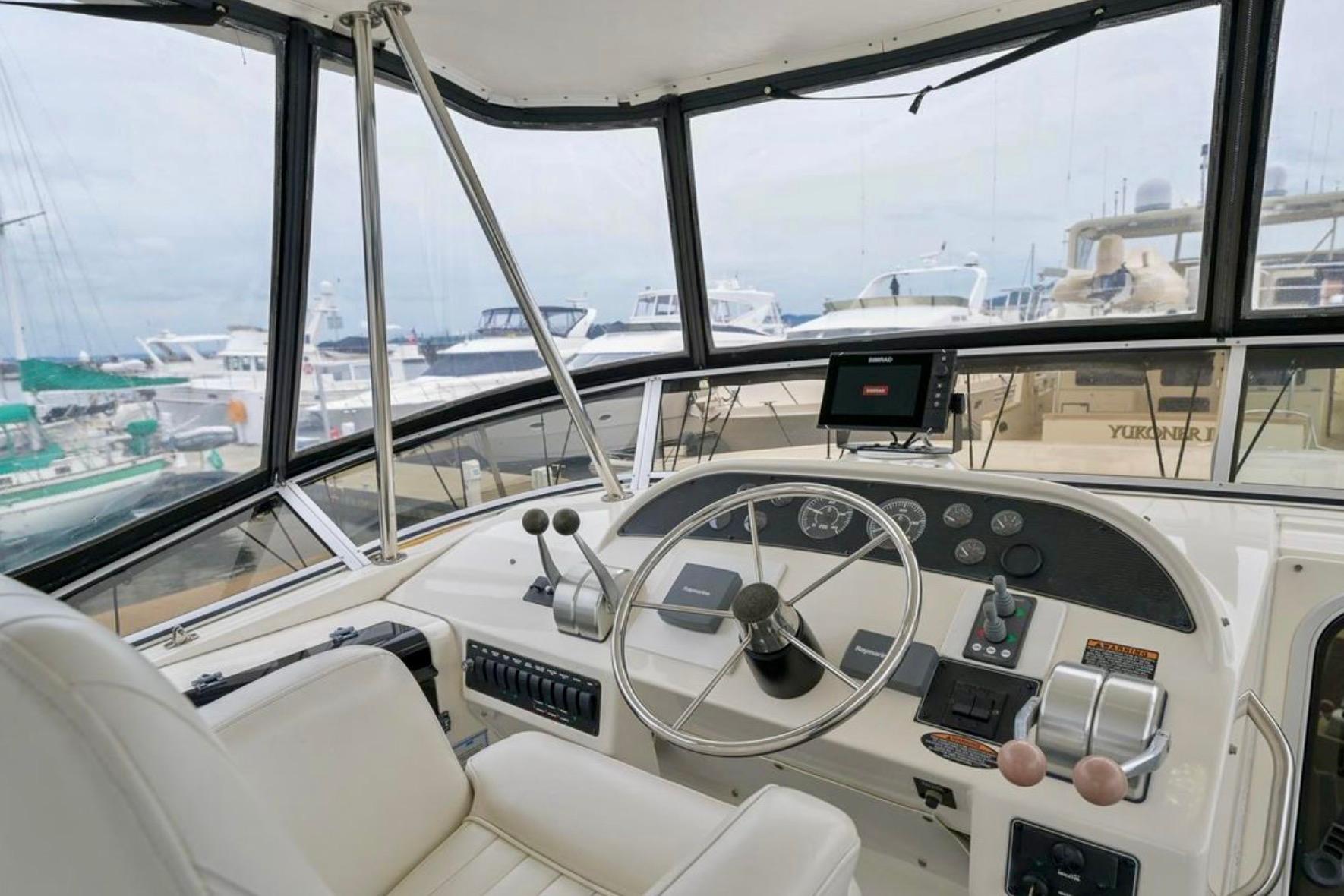 2004 Meridian 490 Pilothouse interior with steering wheel and navigation equipment.