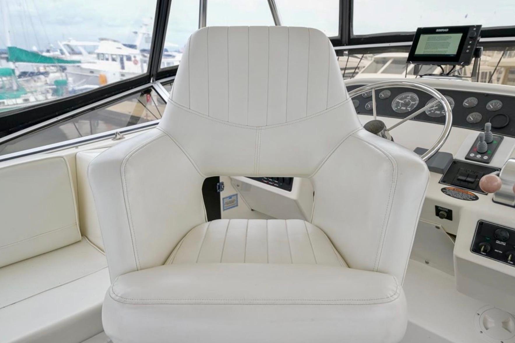 Captain's chair in 2004 Meridian 490 Pilothouse yacht cockpit, featuring navigation controls.