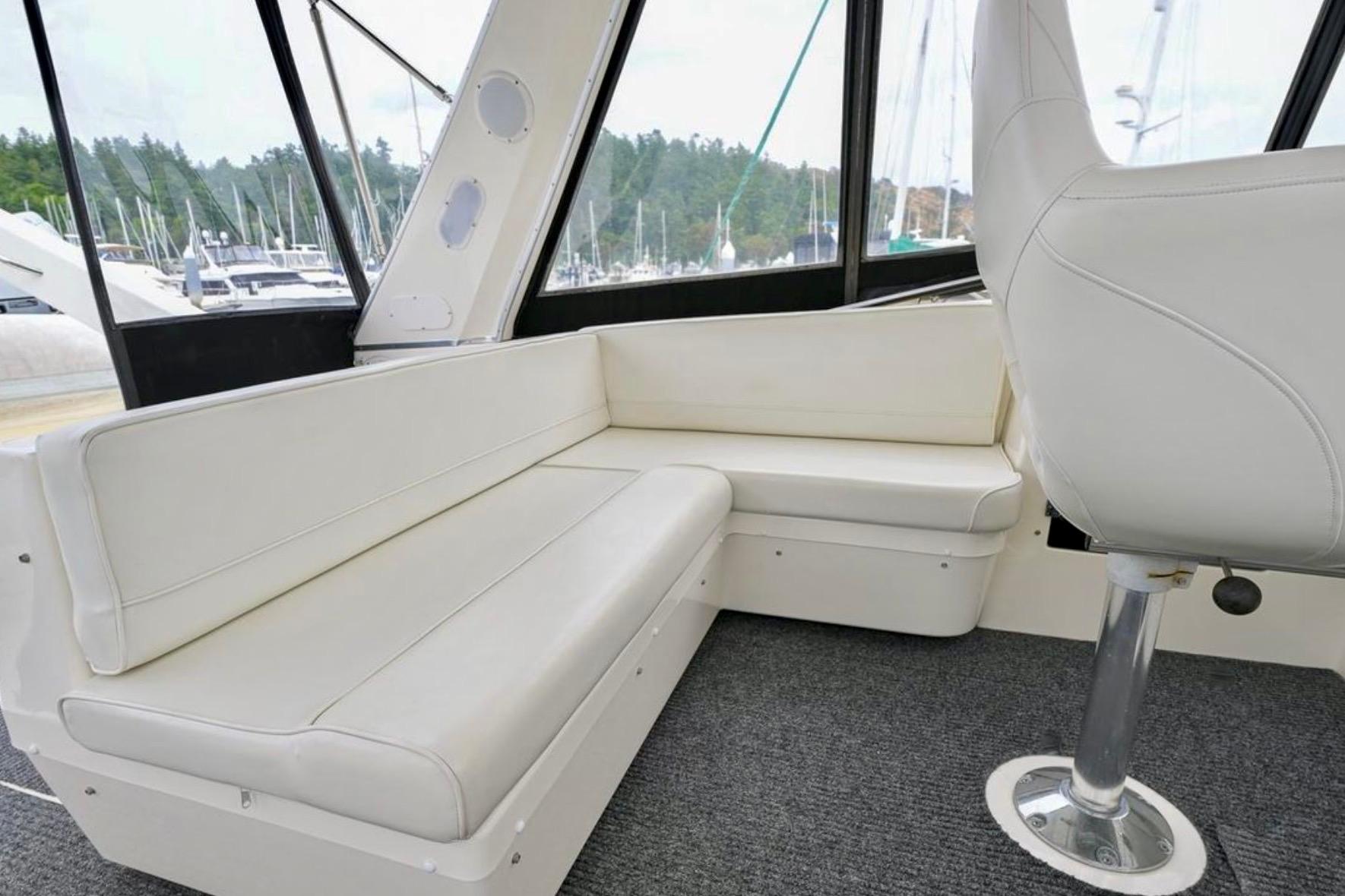 Luxurious interior of 2004 Meridian 490 Pilothouse with white seating and panoramic windows.