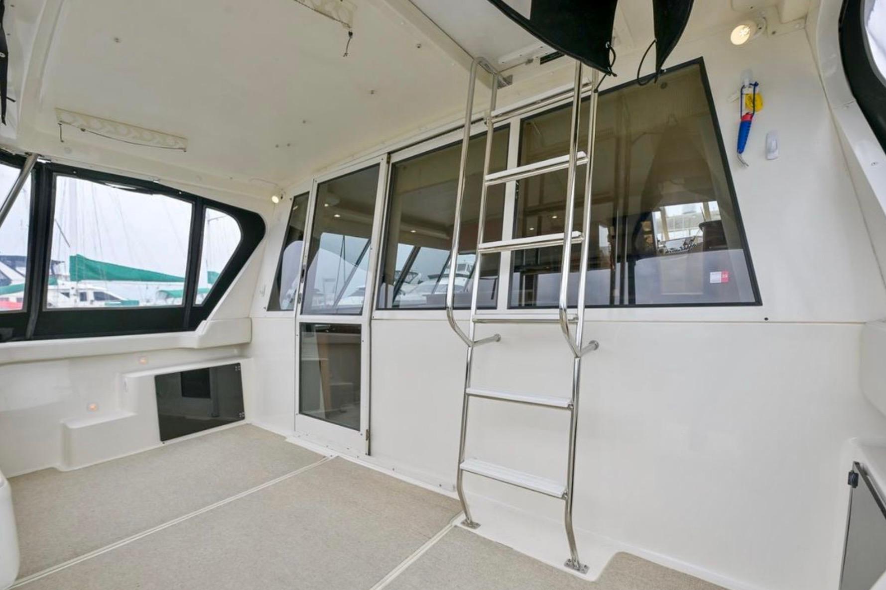 2004 Meridian 490 Pilothouse interior with ladder and large windows.