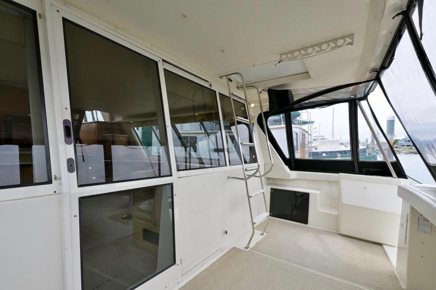 2004 Meridian 490 Pilothouse interior with sliding glass doors and ladder.