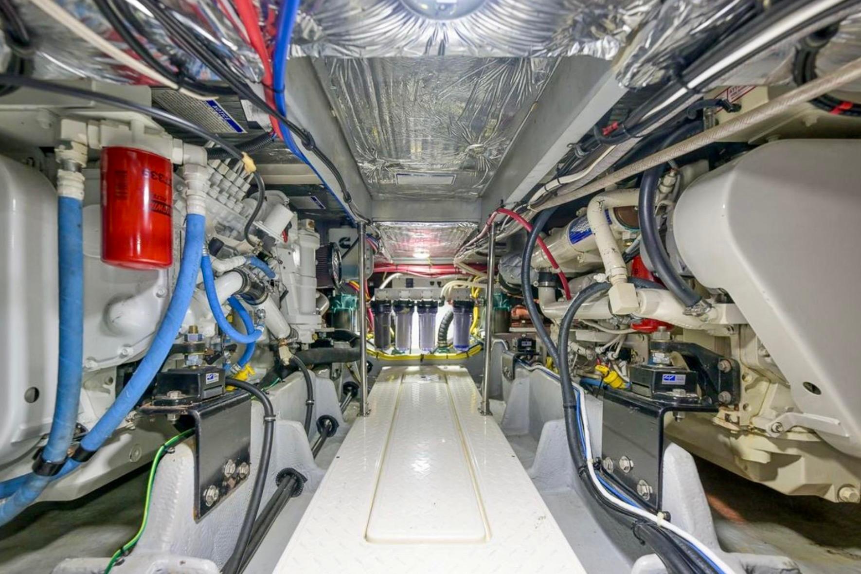 Engine room of 2004 Meridian 490 Pilothouse yacht, showcasing complex machinery and wiring.