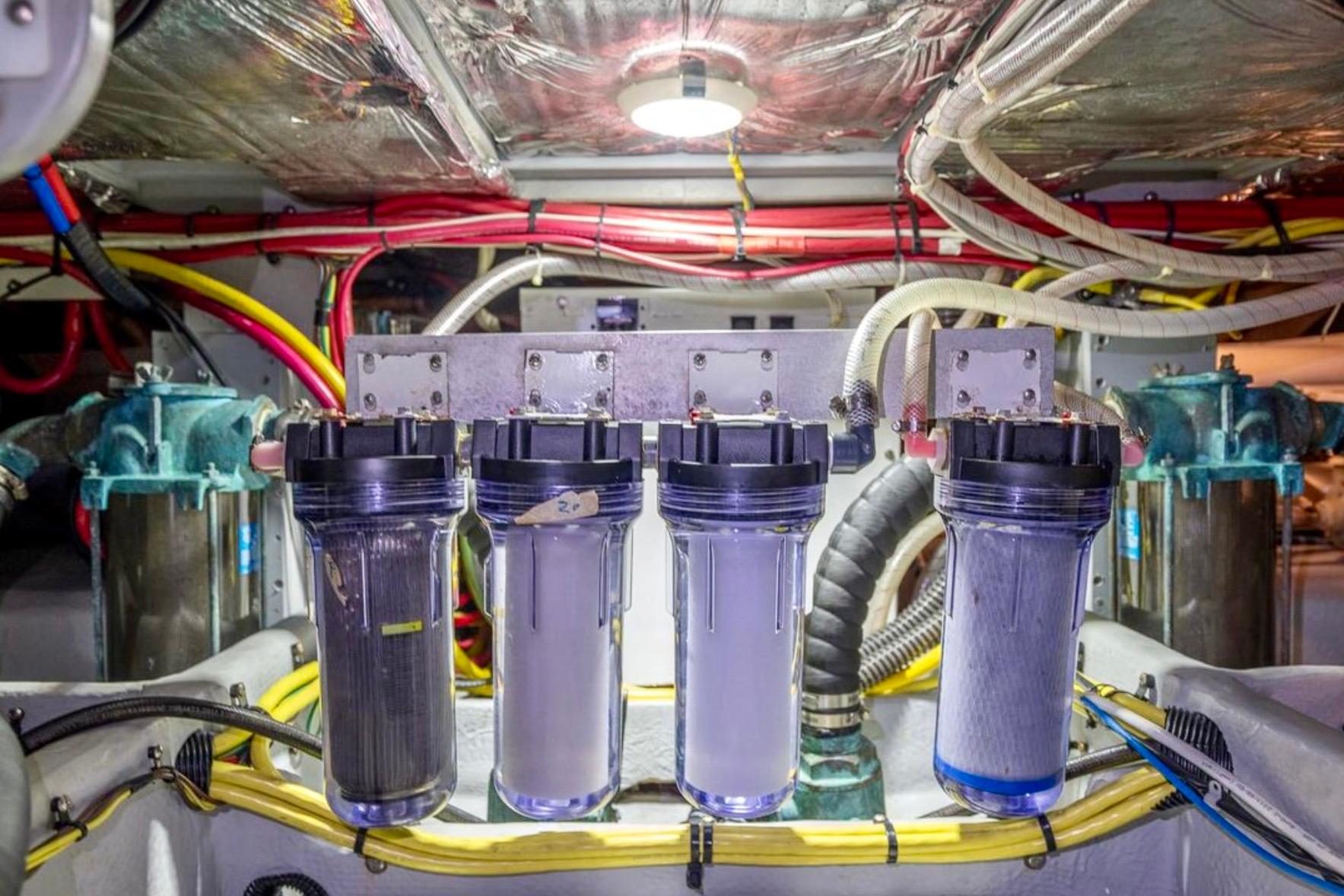 Engine room of 2004 Meridian 490 Pilothouse with water filtration system and wiring.
