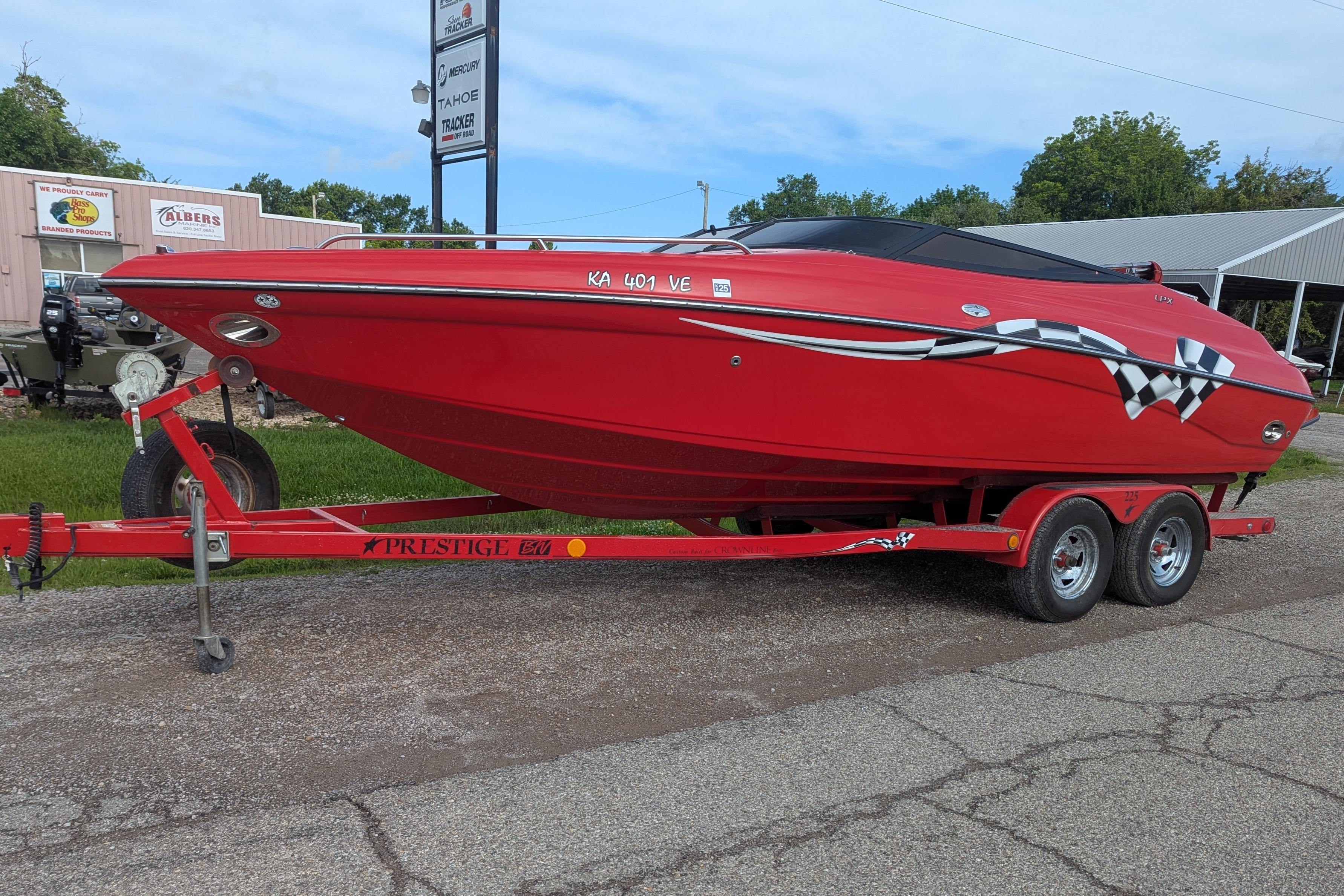Red 2004 Crownline 225 BR boat on trailer, parked outdoors.