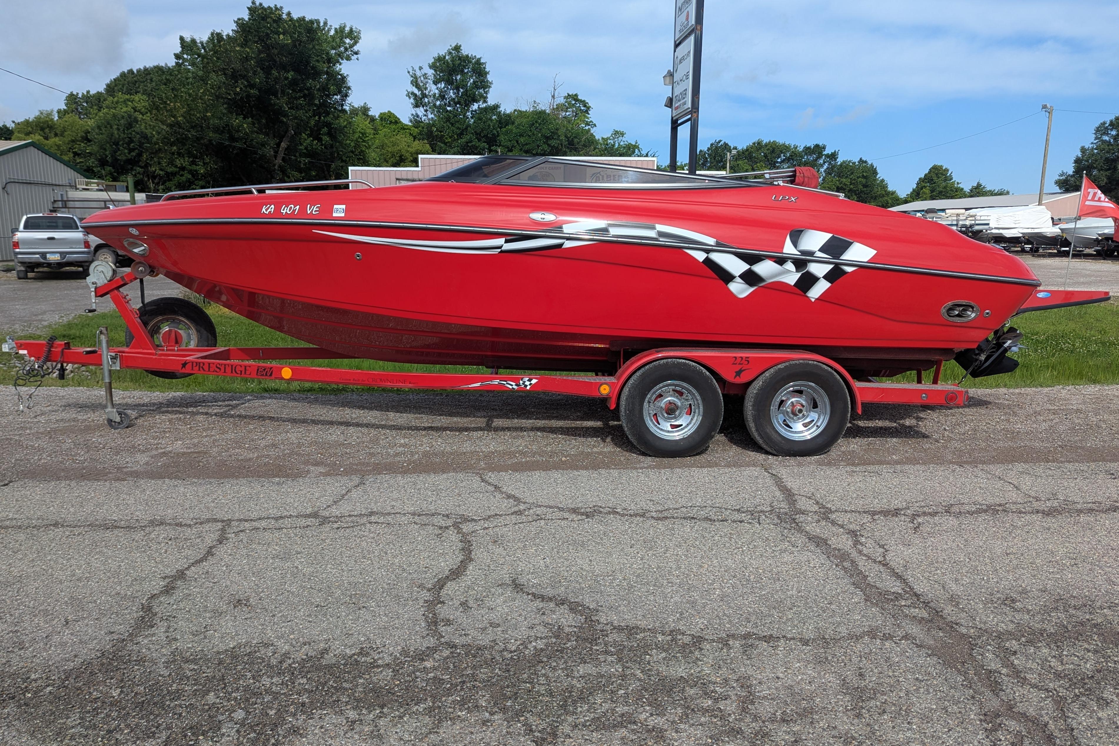Red 2004 Crownline 225 BR boat on trailer, parked outdoors.