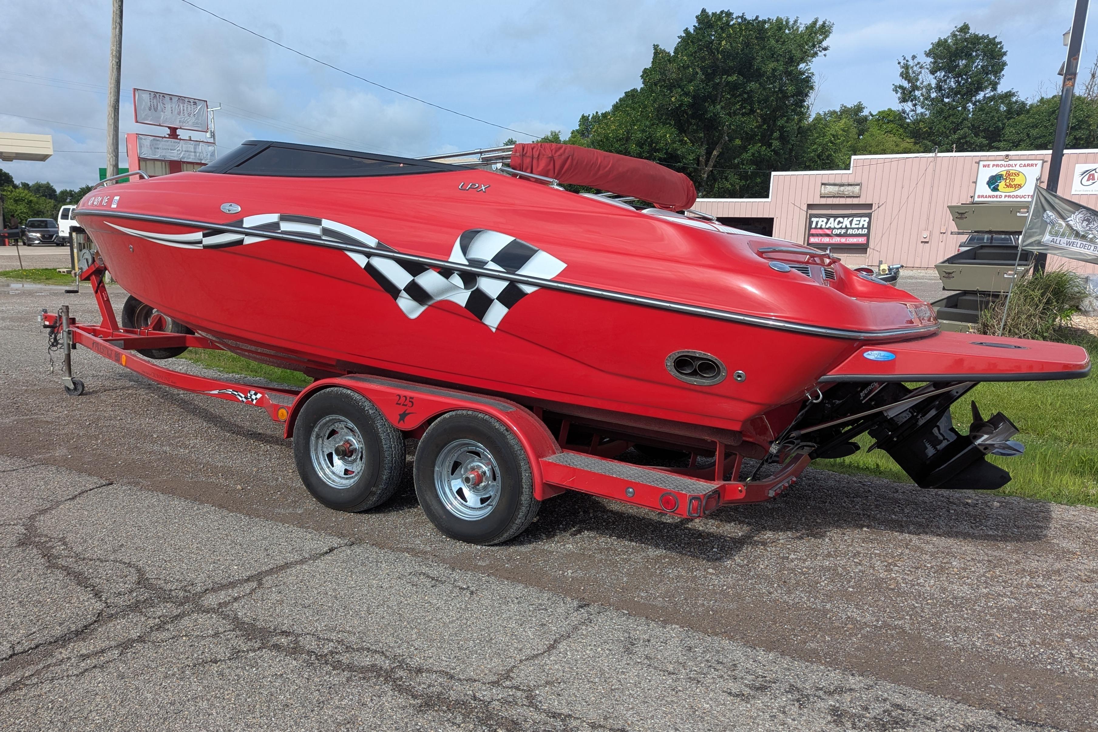 Red 2004 Crownline 225 BR boat on trailer with checkered flag design.