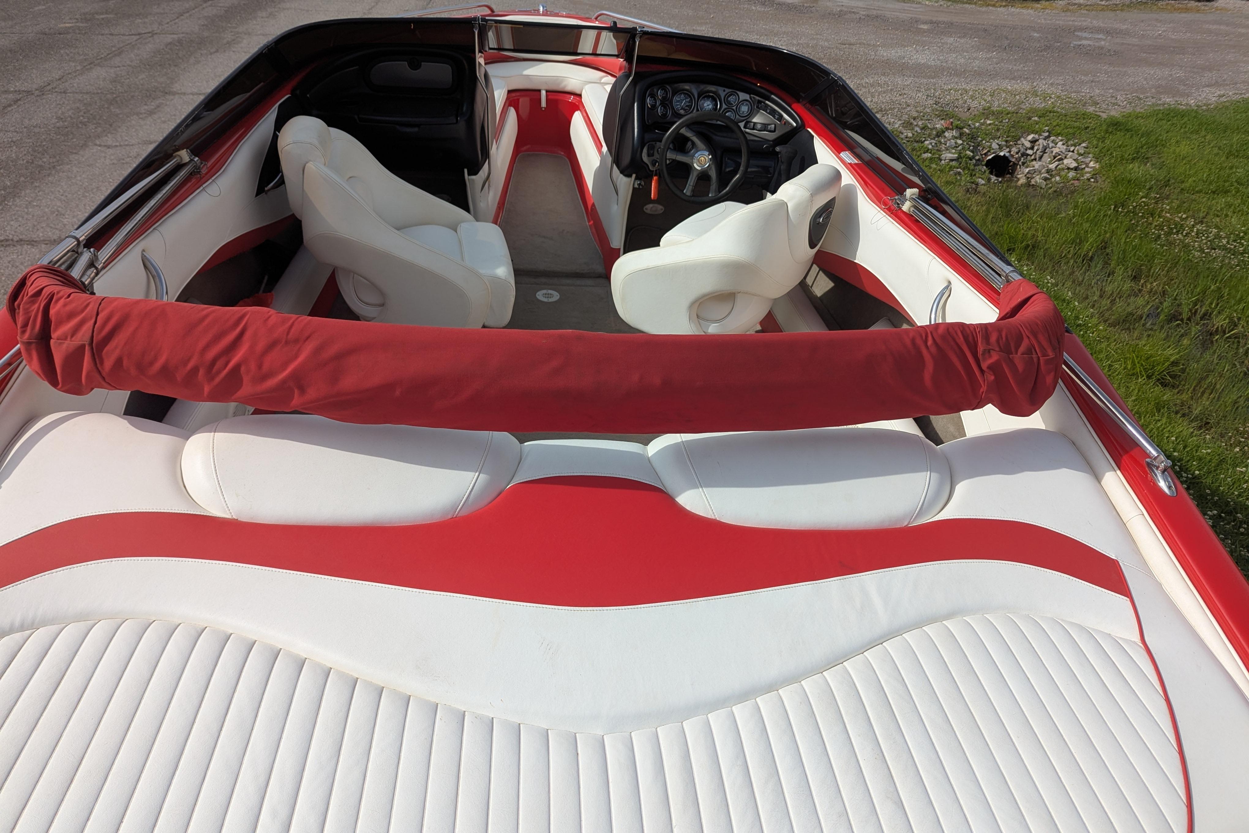2004 Crownline 225 BR boat interior with red and white seating and steering wheel.