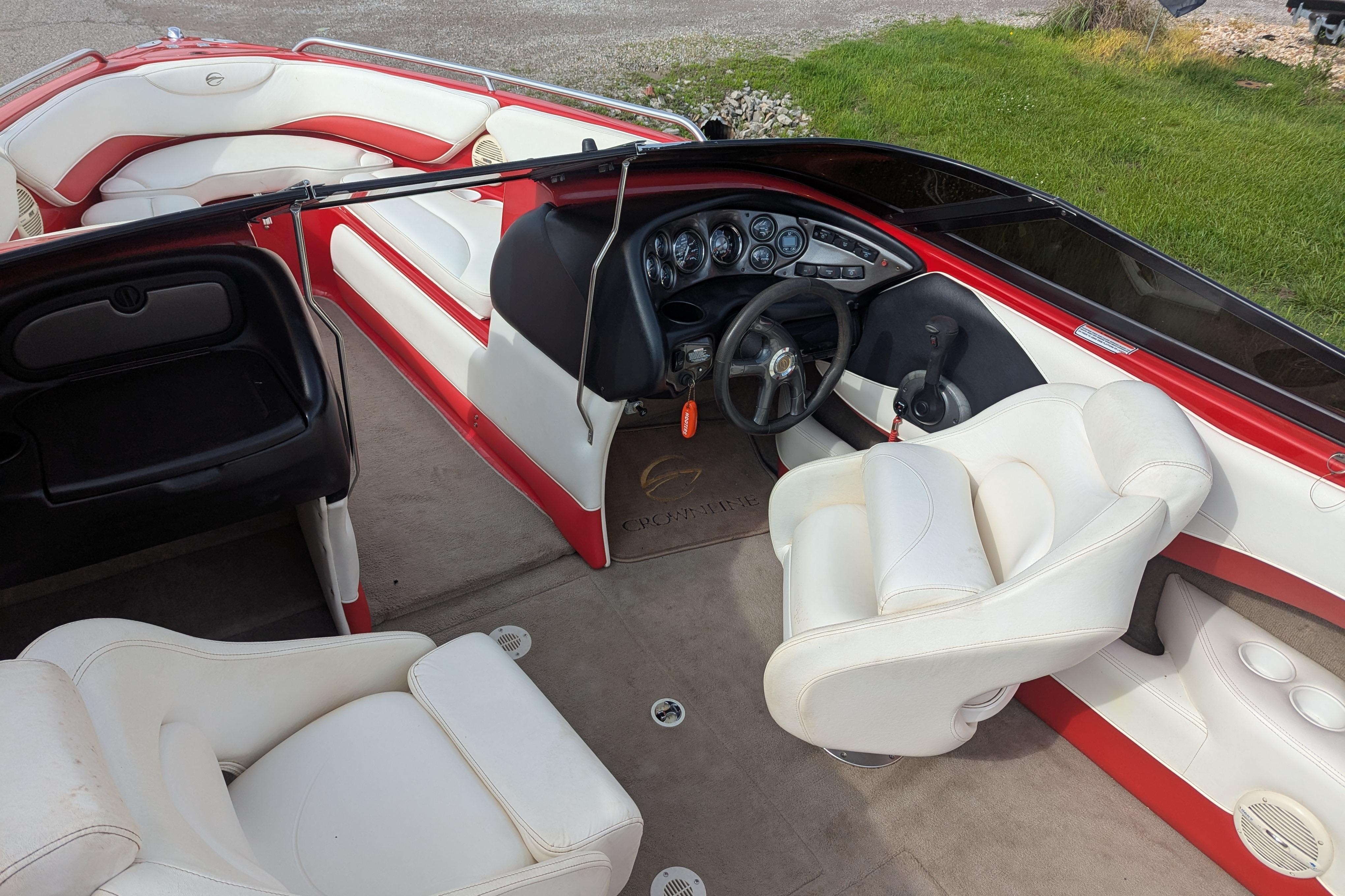 2004 Crownline 225 BR boat interior with white and red seating, steering wheel, and dashboard.
