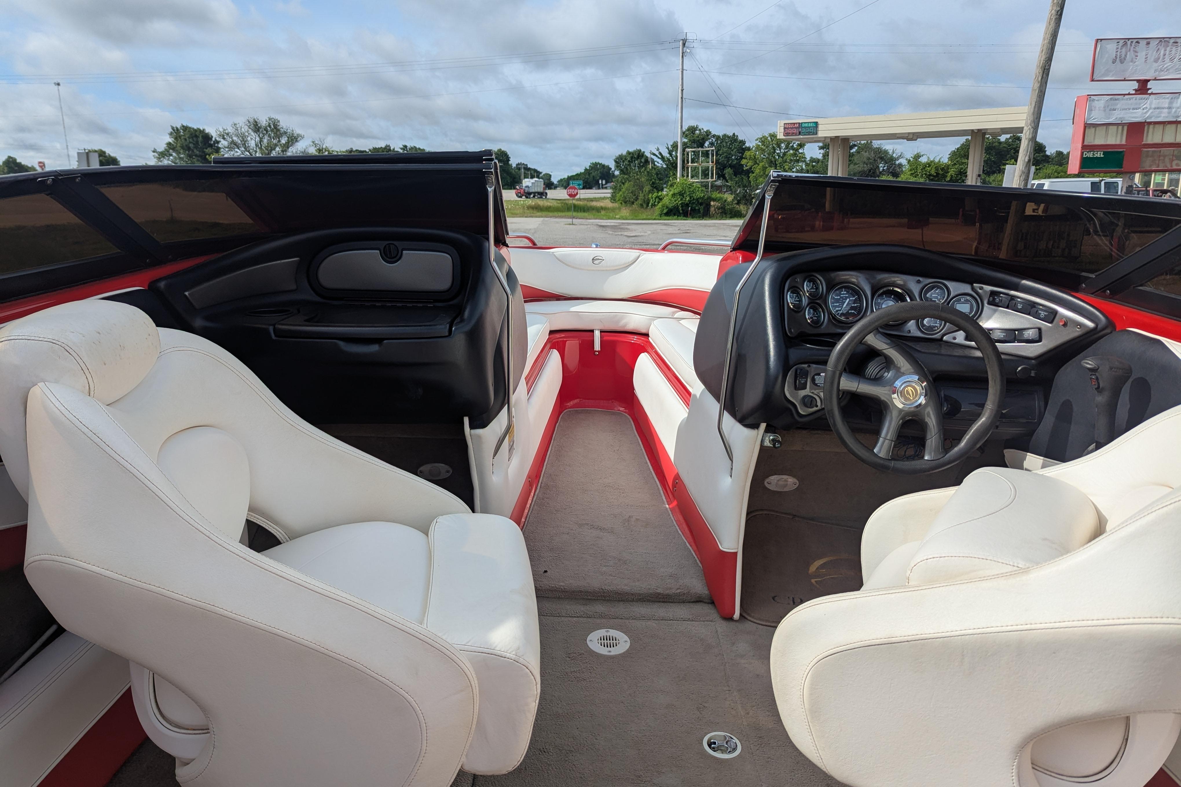 2004 Crownline 225 BR boat interior with white seats and dashboard, parked outdoors.