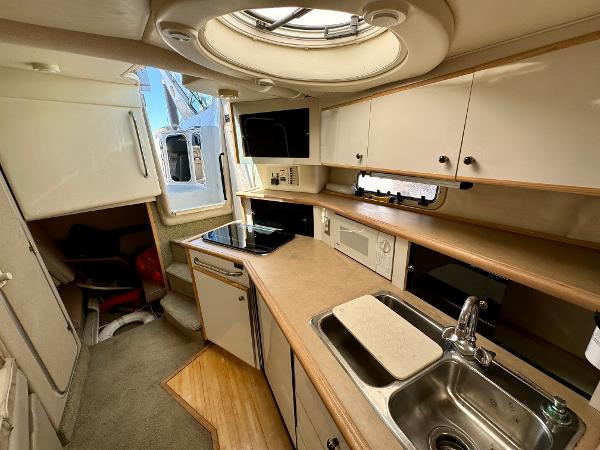 1997 Maxum 3200 SCR boat interior with kitchenette, sink, and storage cabinets.