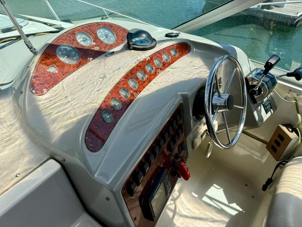 1997 Maxum 3200 SCR boat dashboard with steering wheel and control panel.