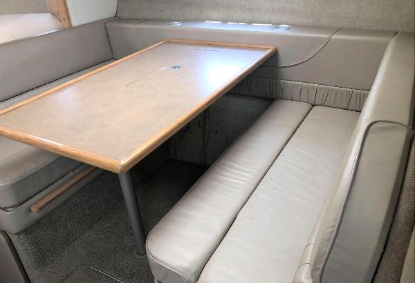 1997 Maxum 3200 SCR interior with beige seating and wooden table.