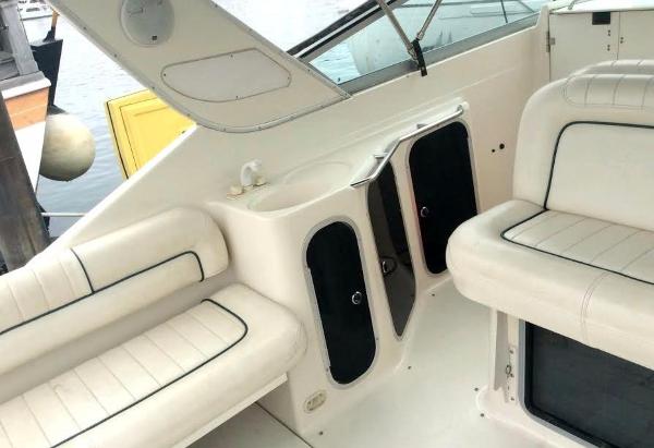 Interior of a 1997 Maxum 3200 SCR boat with white seating and storage compartments.