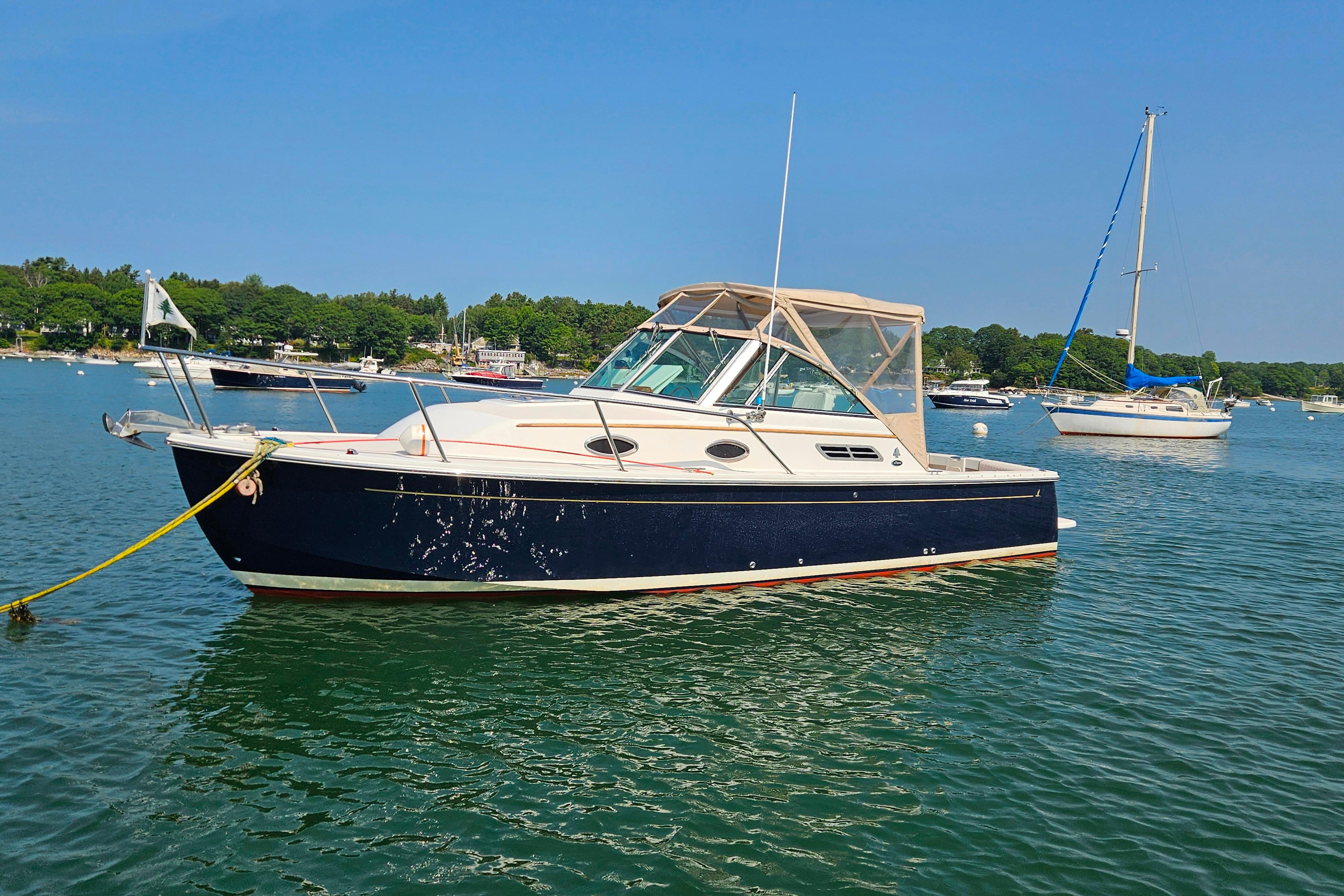 2006 Back Cove 26 boat anchored in a scenic harbor with sailboats.