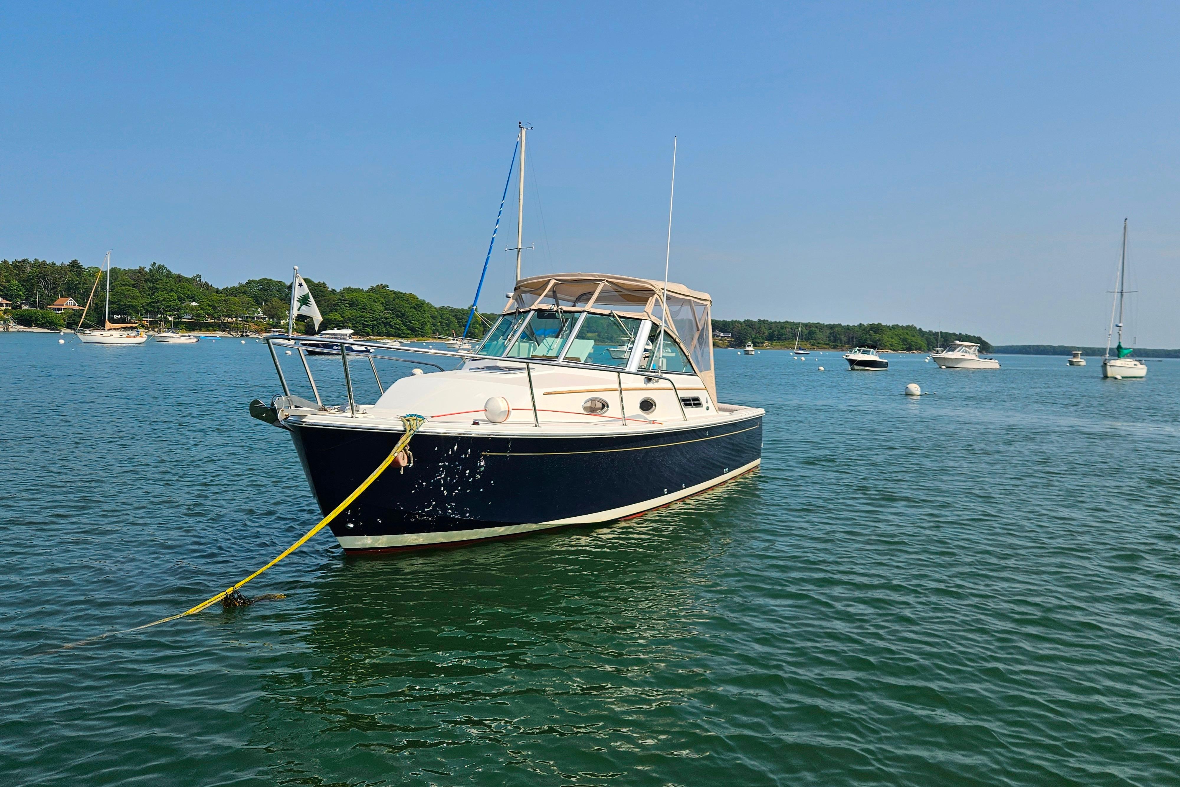 2006 Back Cove 26 boat anchored in a scenic bay with other vessels.