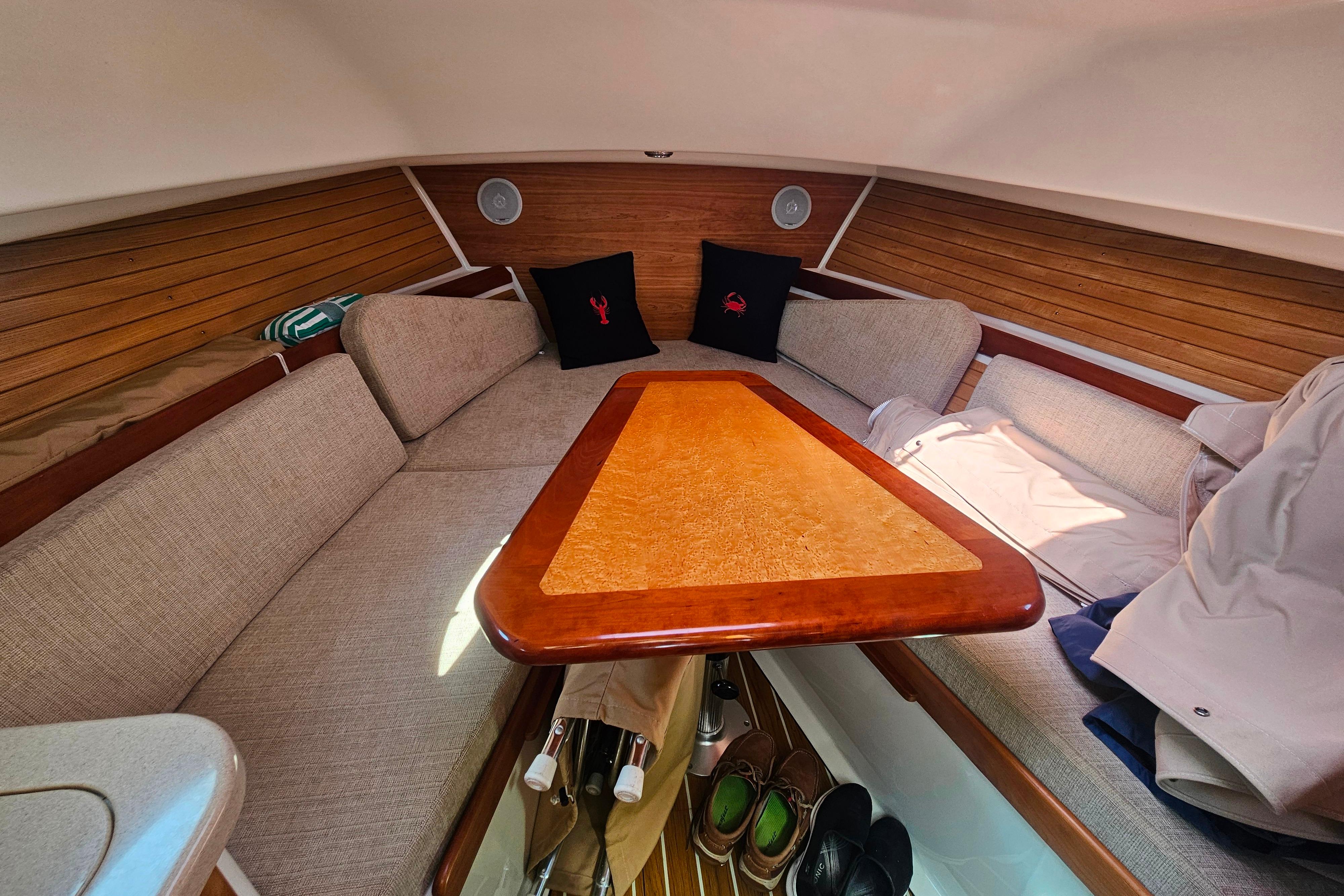 2006 Back Cove 26 boat interior with cozy seating and wooden table.