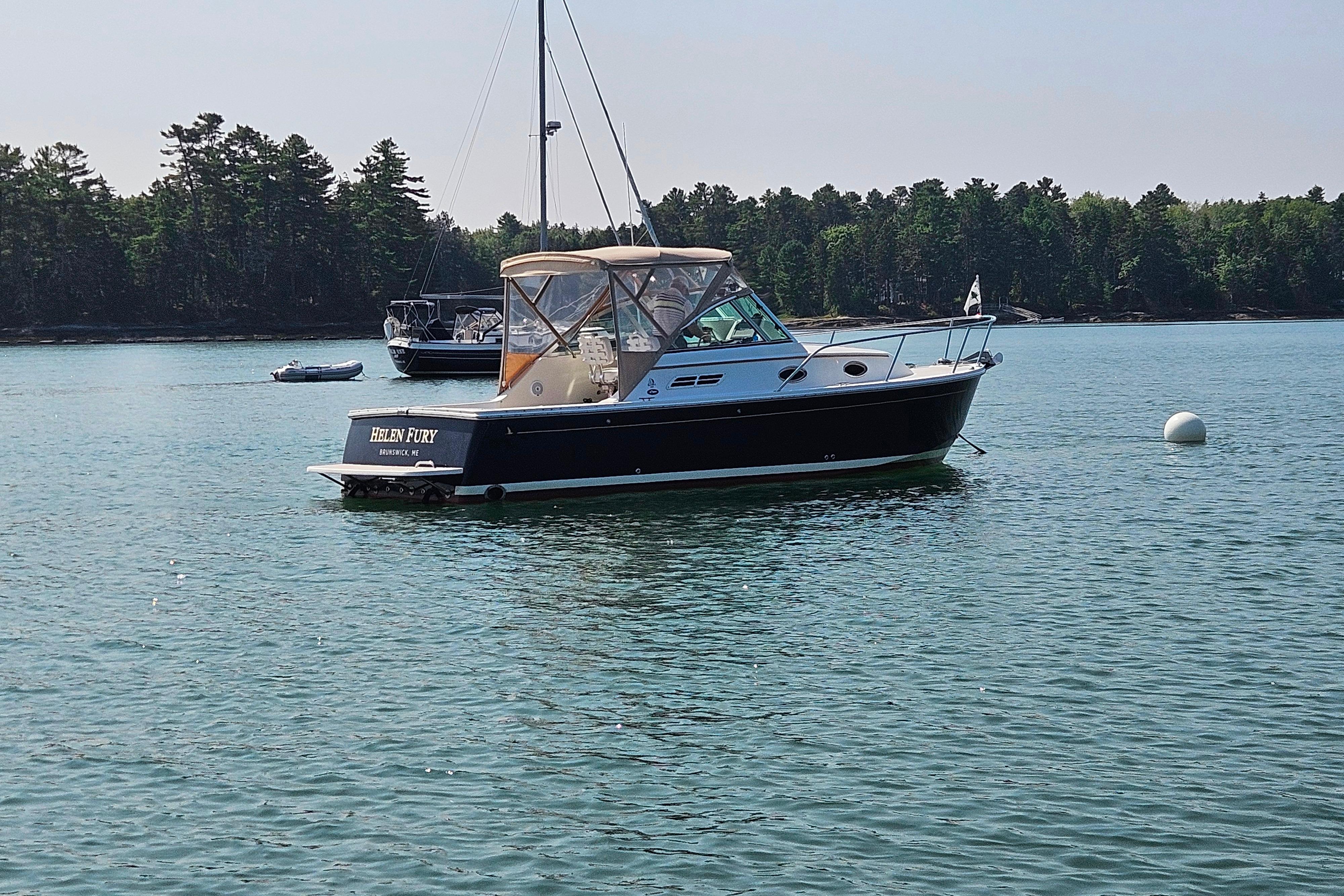 2006 Back Cove 26 boat anchored on calm water with forested shoreline.