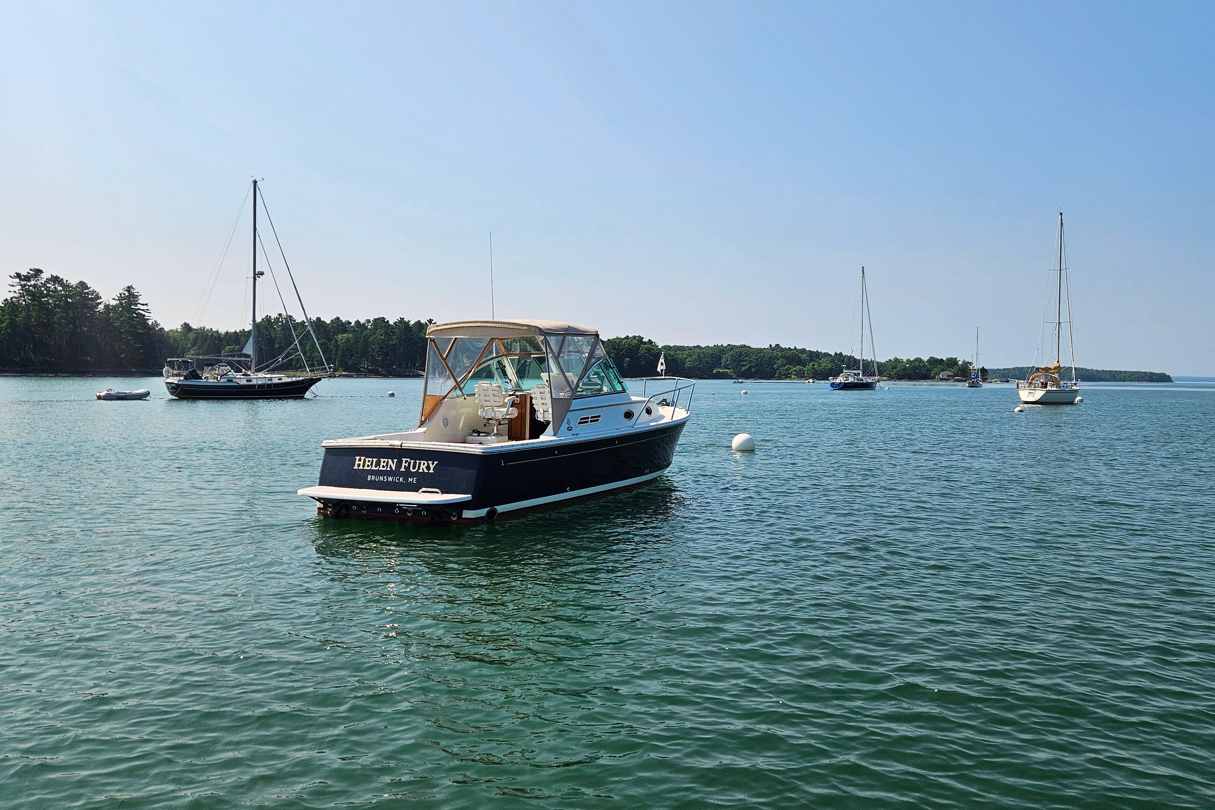 2006 Back Cove 26 boat named u0022Helen Furyu0022 on a serene lake with sailboats.
