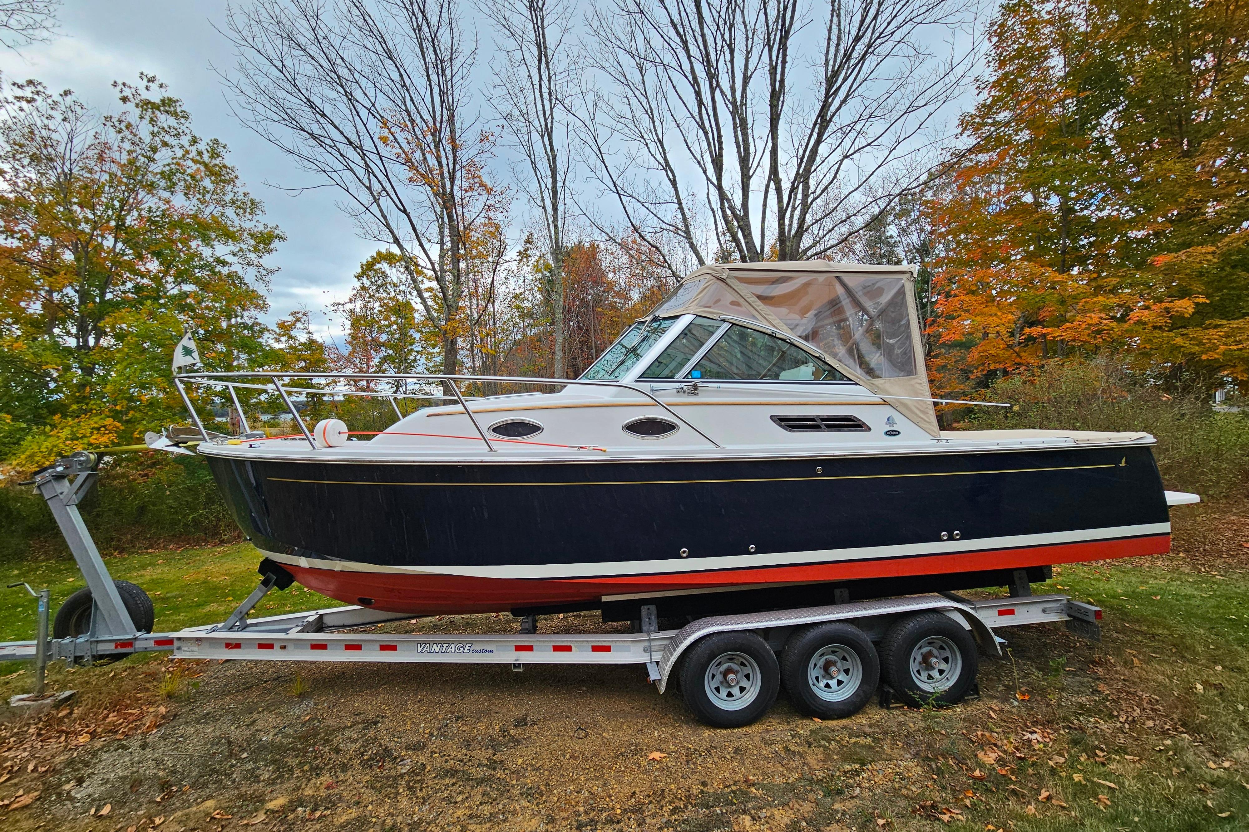 2006 Back Cove 26 boat on trailer, surrounded by autumn trees.
