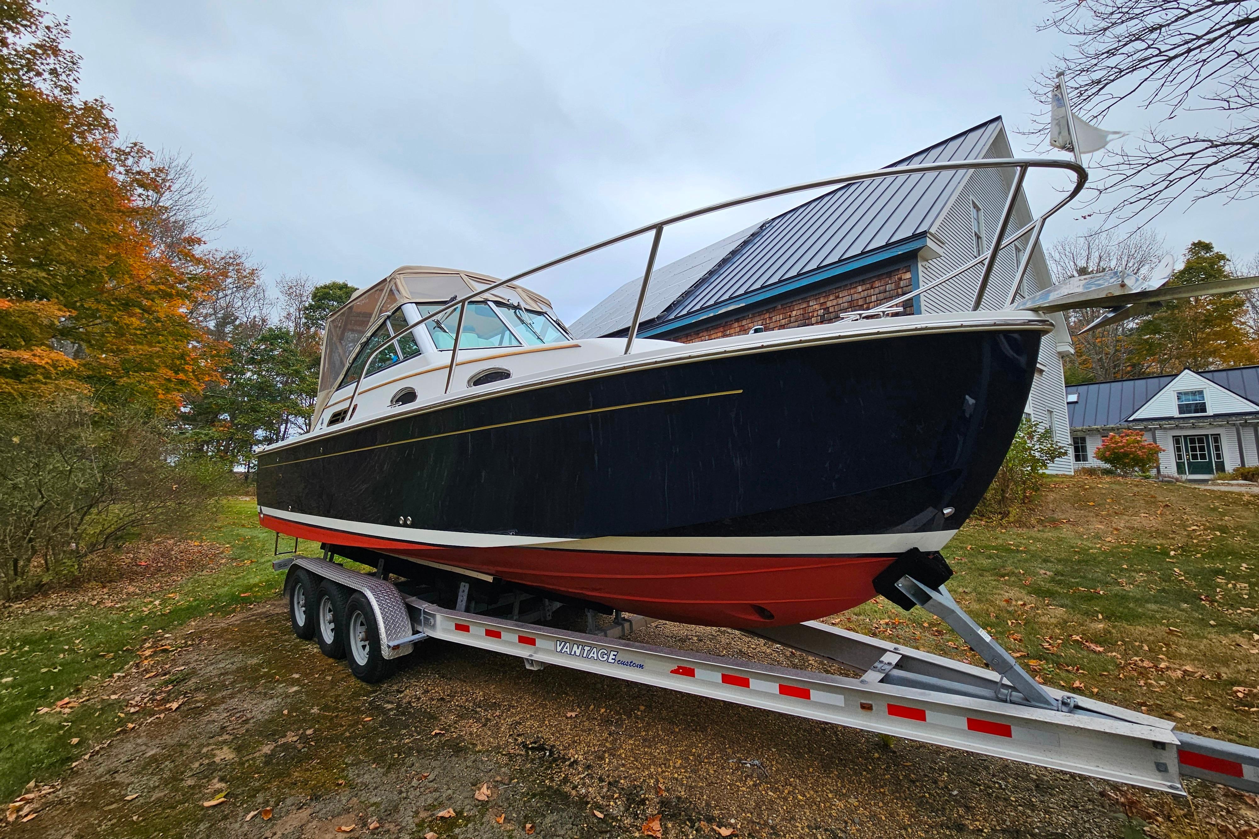 2006 Back Cove 26 boat on trailer, autumn setting, near house.