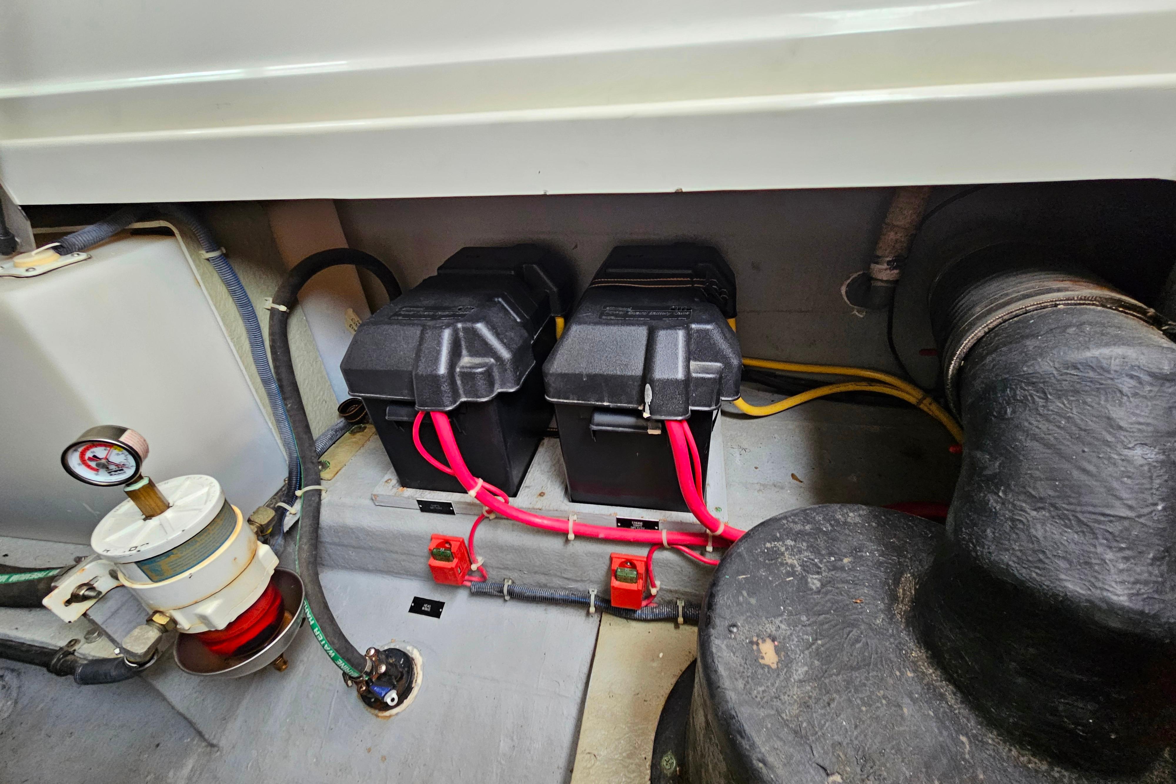 Engine compartment of a 2006 Back Cove 26 boat with batteries and wiring.