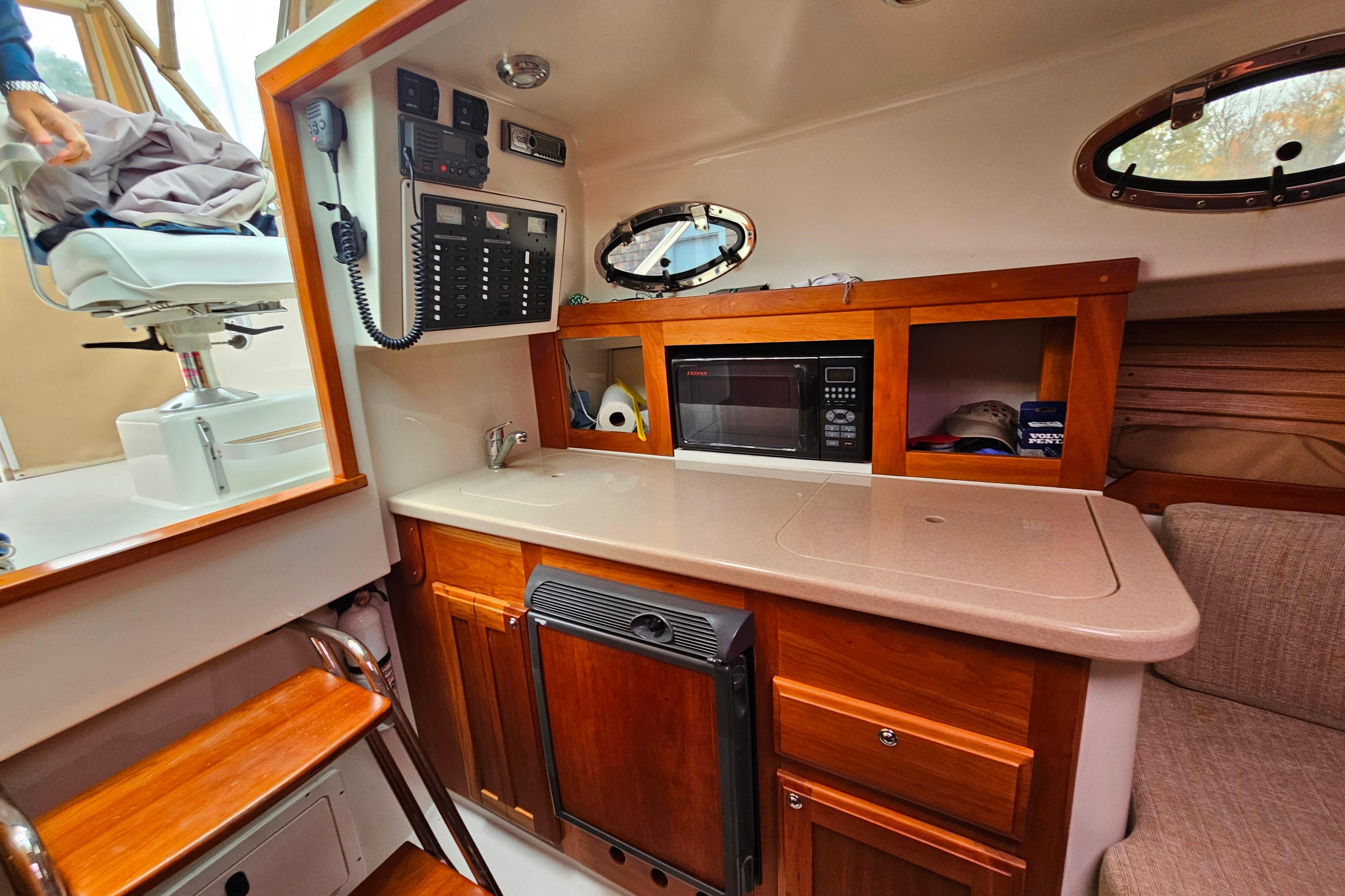 2006 Back Cove 26 interior with kitchenette, microwave, and control panel.