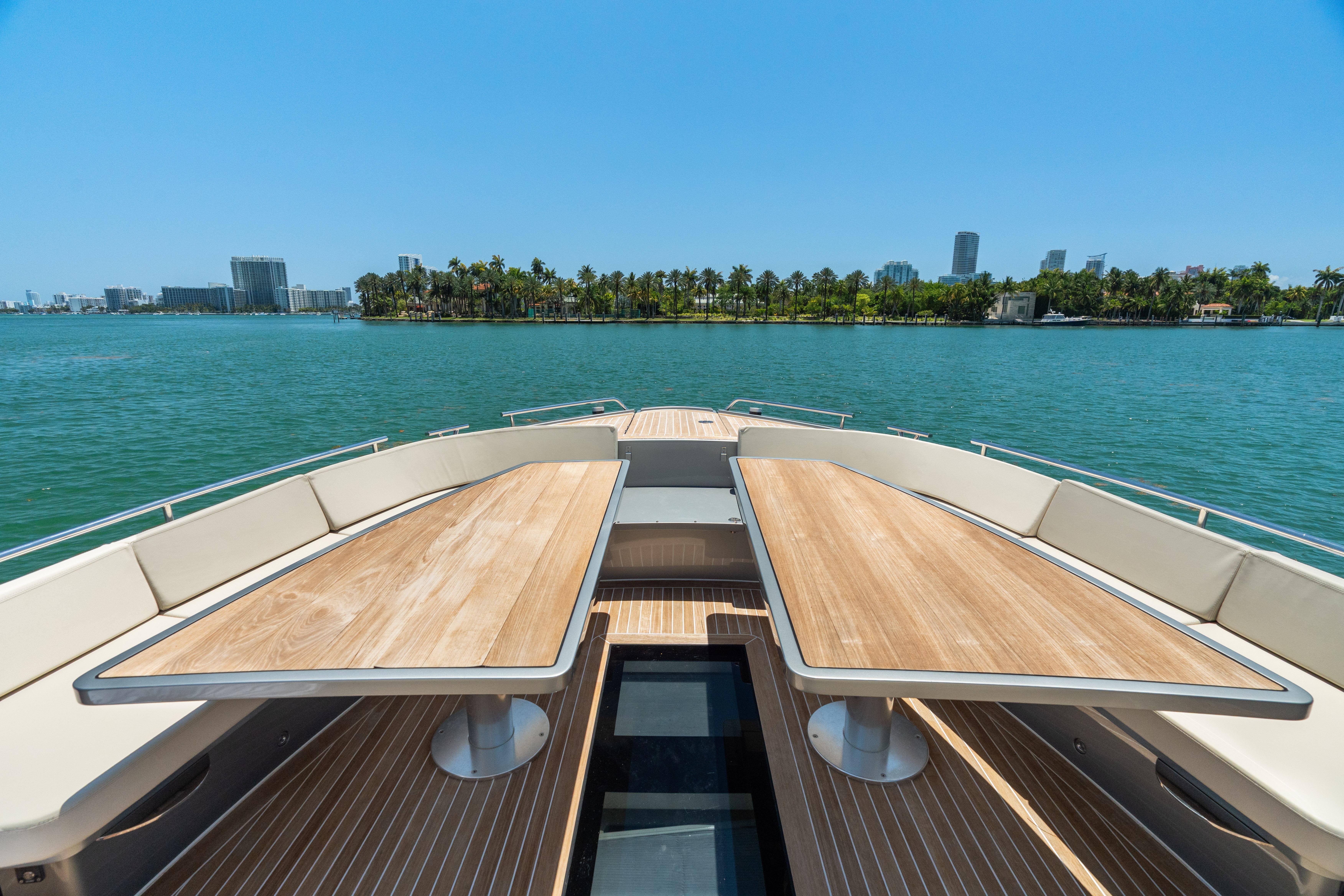 CNM-Continental 54 2019-YANINA FL-US-Luxurious 2019 CNM Continental 54T yacht deck with wooden tables, overlooking serene waters and cityscape.-9803754 | Thumbnail