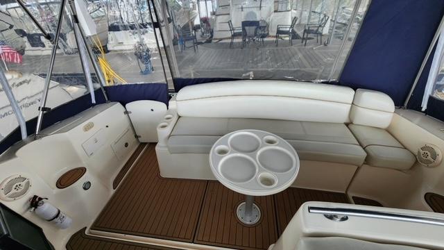 2005 Rinker Fiesta Vee 342 boat interior with seating and table in a marina setting.