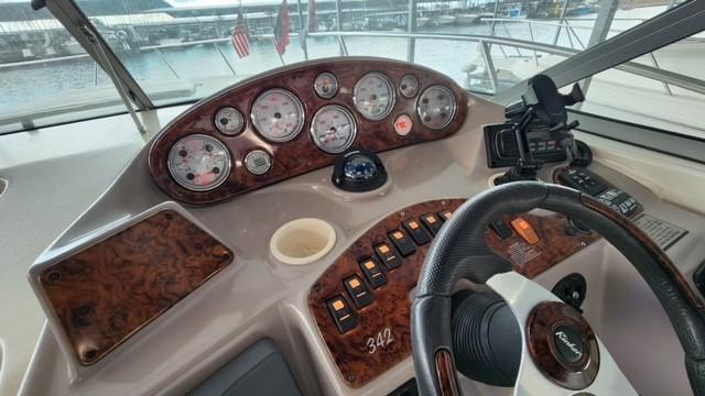 2005 Rinker Fiesta Vee 342 dashboard with gauges and controls, overlooking marina.