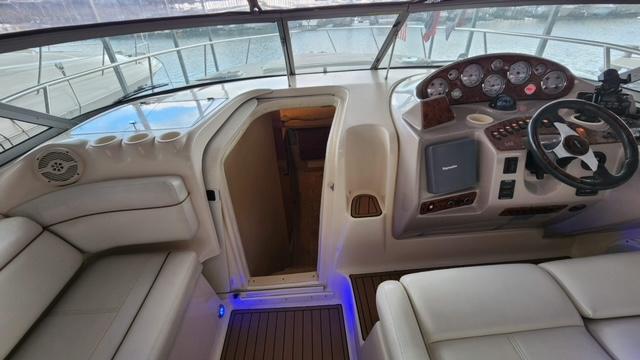 2005 Rinker Fiesta Vee 342 cockpit with steering wheel, seating, and cabin entrance.