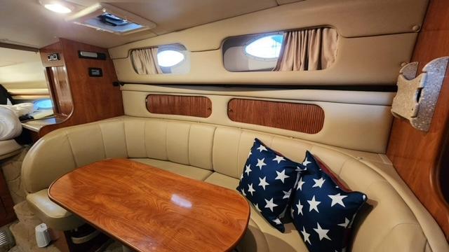 Interior of 2005 Rinker Fiesta Vee 342 with cozy seating and star-patterned pillows.