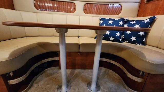 Interior of 2005 Rinker Fiesta Vee 342 with curved seating and star-patterned pillows.