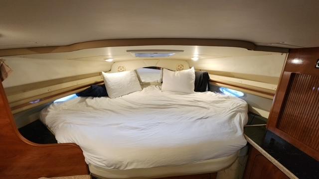 Interior cabin of 2005 Rinker Fiesta Vee 342 with cozy bed and pillows.