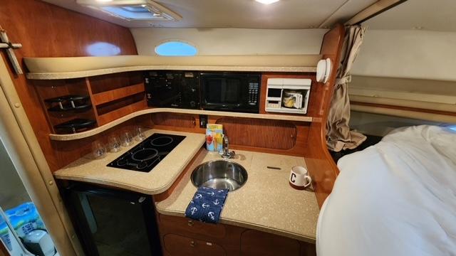 2005 Rinker Fiesta Vee 342 boat interior with kitchenette and cozy sleeping area.