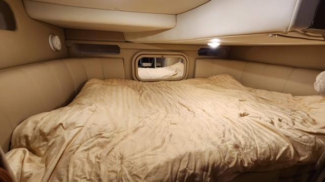 2005 Rinker Fiesta Vee 342 cabin with a cozy bed and ambient lighting.